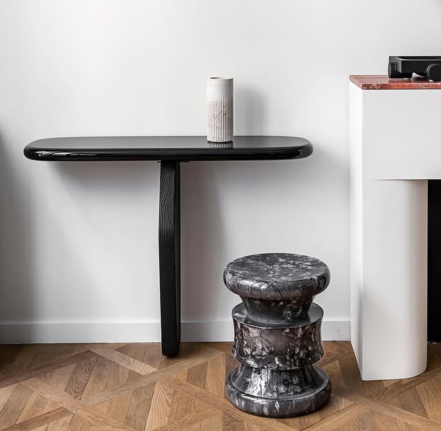 The Ignis Console and the Barth Stool in enameled lava stone engage in a dialogue between heritage and innovation.